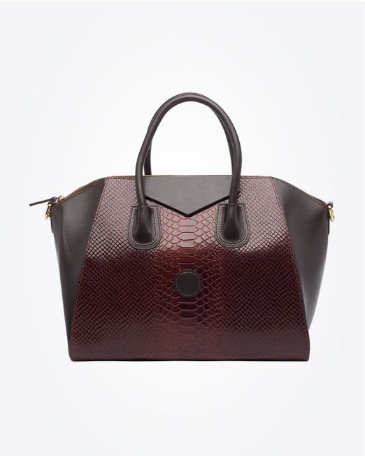 A stylish handbag with dark brown handles and sides, featuring a textured, burgundy reptile-skin pattern on the front and center, set against a plain white background.