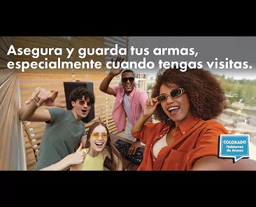 Four friends smiling while taking a selfie together on a balcony with the Spanish text: Asegura y guarda tus armas, especialmente cuando tengas visitas.
