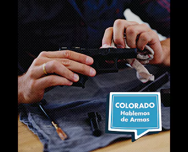 Hands cleaning a handgun with a cloth, with a speech bubble text overlay that reads COLORADO Hablemos de Armas.